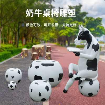 戶(hù)外園林中一只坐著看書(shū)的奶牛桌椅玻璃鋼牛雕塑