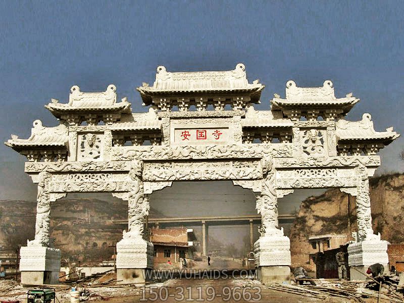 景區(qū)安國(guó)寺門(mén)前擺放龍紋浮雕門(mén)樓牌坊雕塑